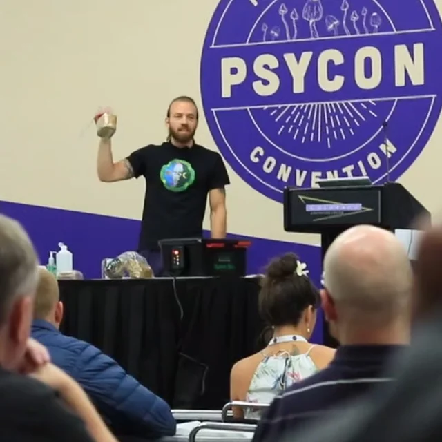 Oliver speaking to an audience at Psycon